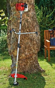 MTD Smart BC52 lutande mot ett träd